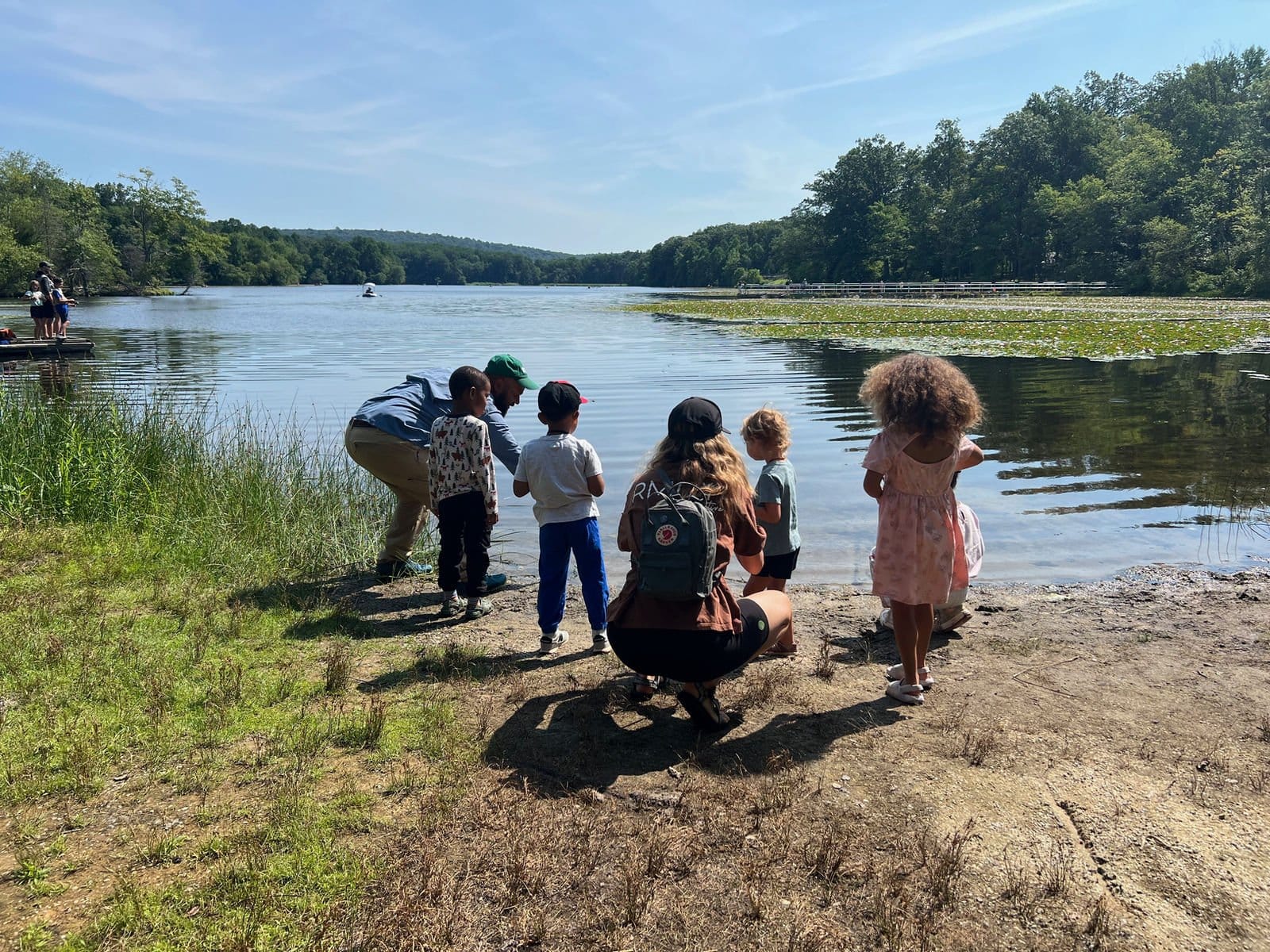 Families fishing together at the edge of a lake